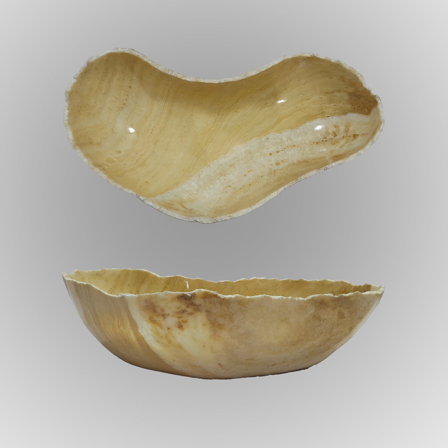 A free form onyx bowl with a smooth, curved shape against a gray background.