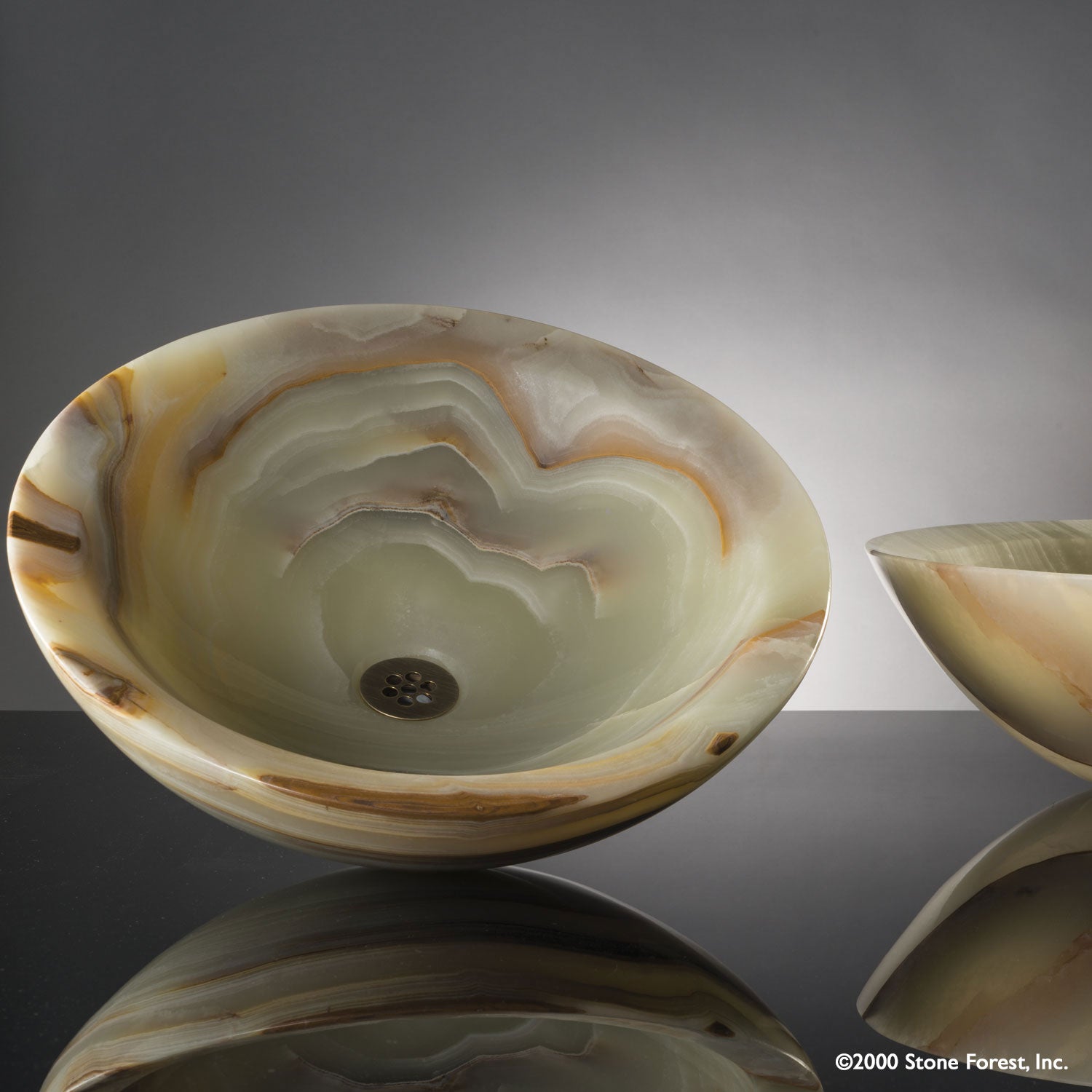Beveled Round vessel sink carved from multi-onyx with a polished finish.