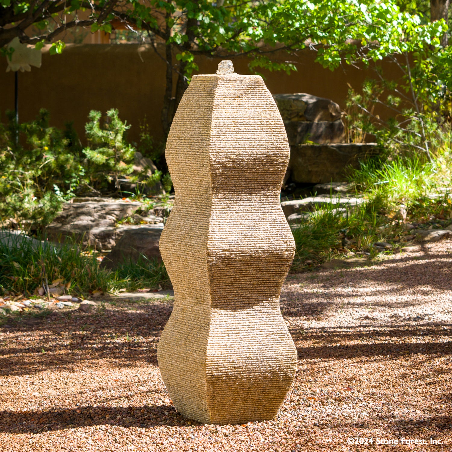 The Wave Fountain sculpted from a block of beige granite.