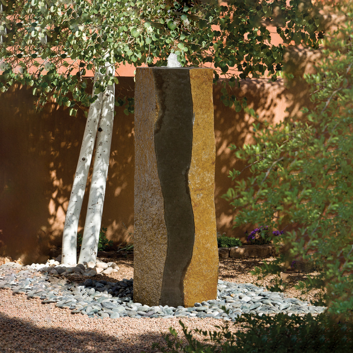 A large basalt column fountain with a polished black and gold stone surface, displayed outoors image 2 of 4