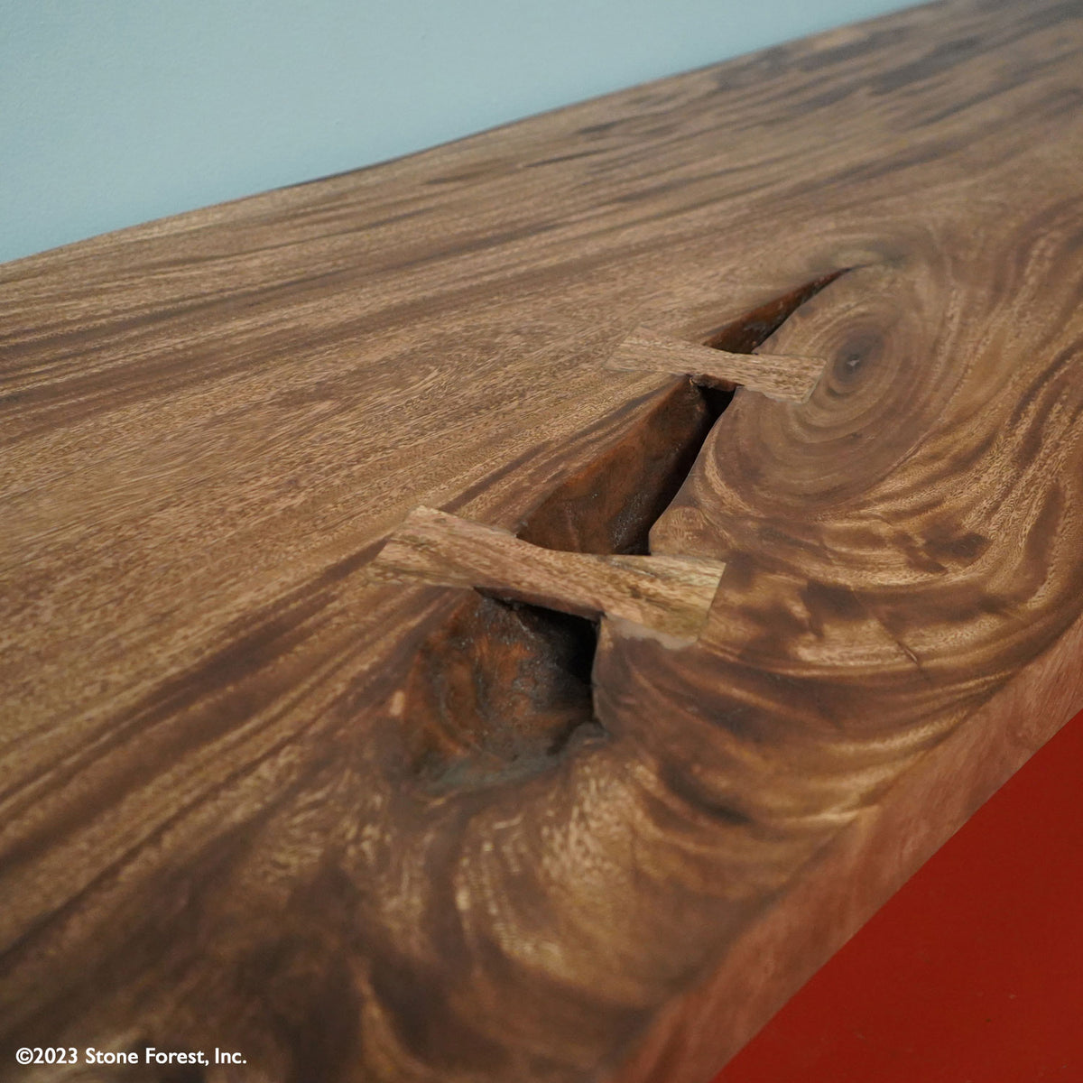 This massive wood bench is truly unique and is a one-of-a-kind piece. hand-made from a thick slab of Acacia hardwood supported by metal legs. Detail view image 3 of 4