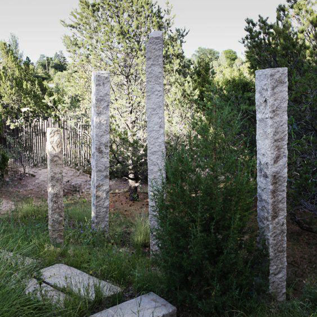 Rough chiseled plinths carved from beige granite used as sculptural accents
