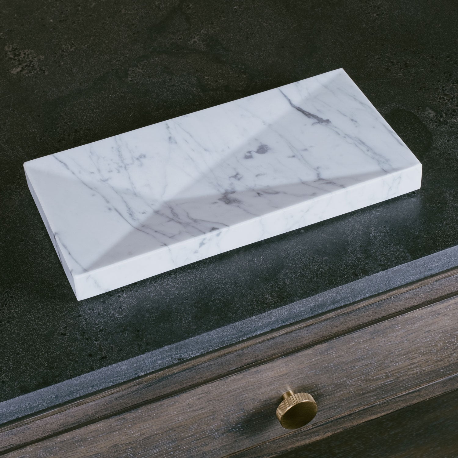 A rectangular Carrara marble bath tray with visible white and gray patterns characteristic of marble stone.