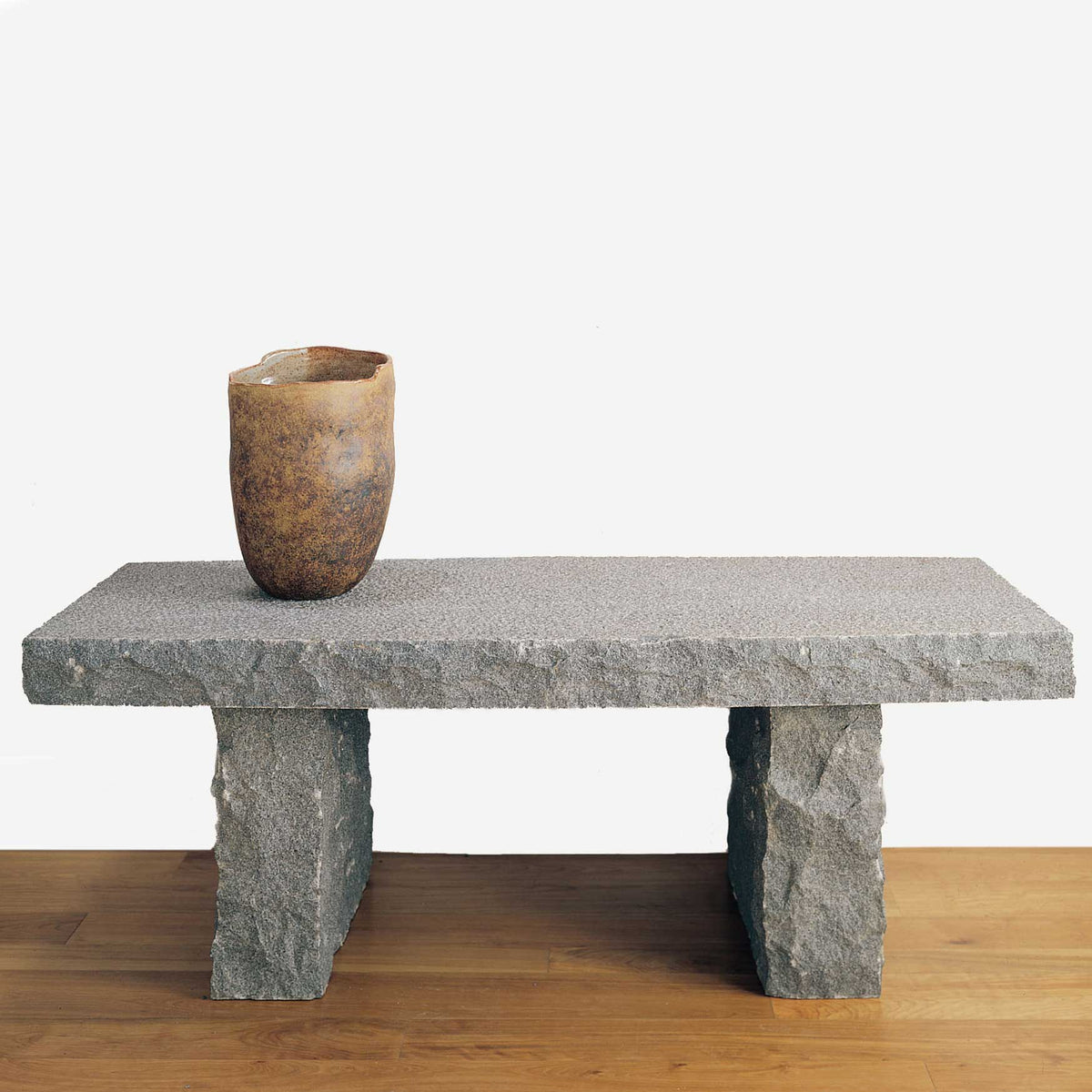 The Stone Forest Classic bench is carved from gray granite. It has a beautiful rough-chiseled finish on the outer edges and a smooth surface on the seat. image 1 of 1