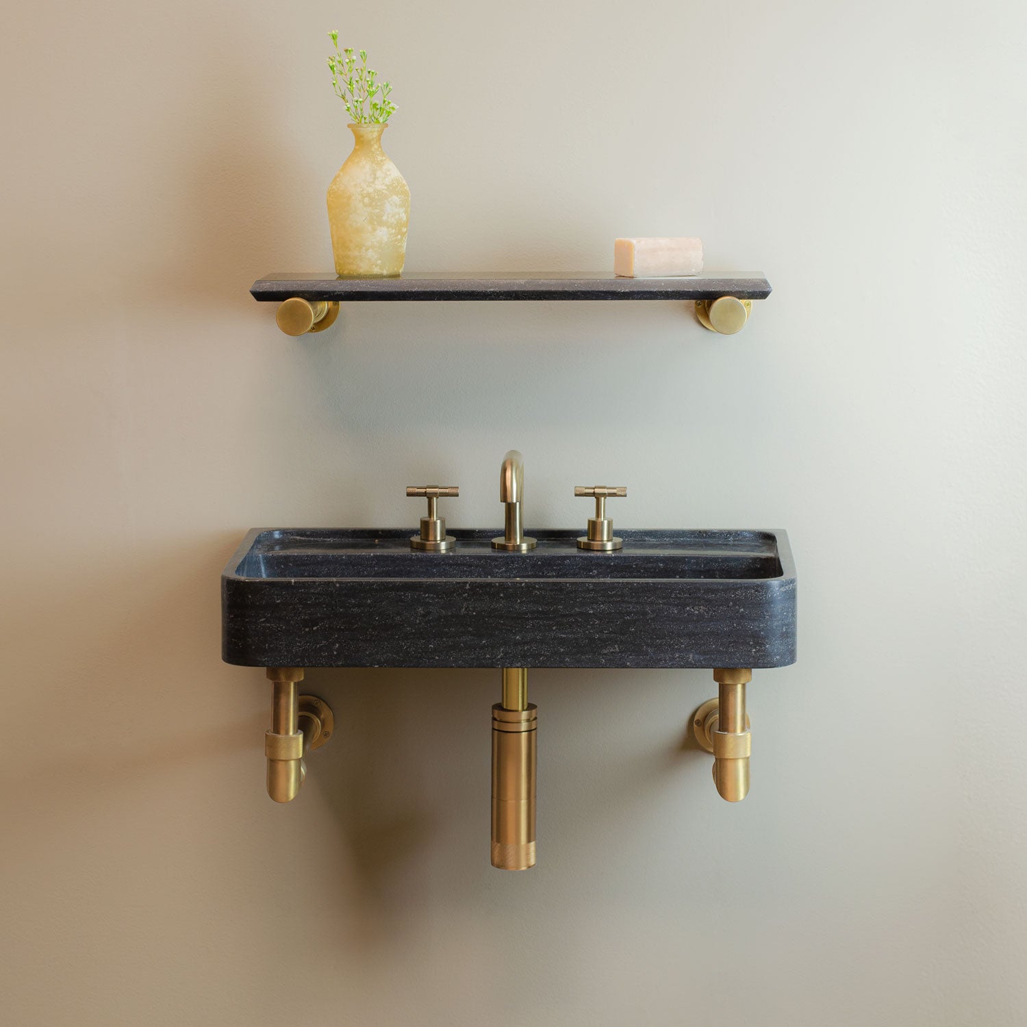 Lumbre Bath Sink in antique gray limestone on Elemental Classic wall unit in aged brass