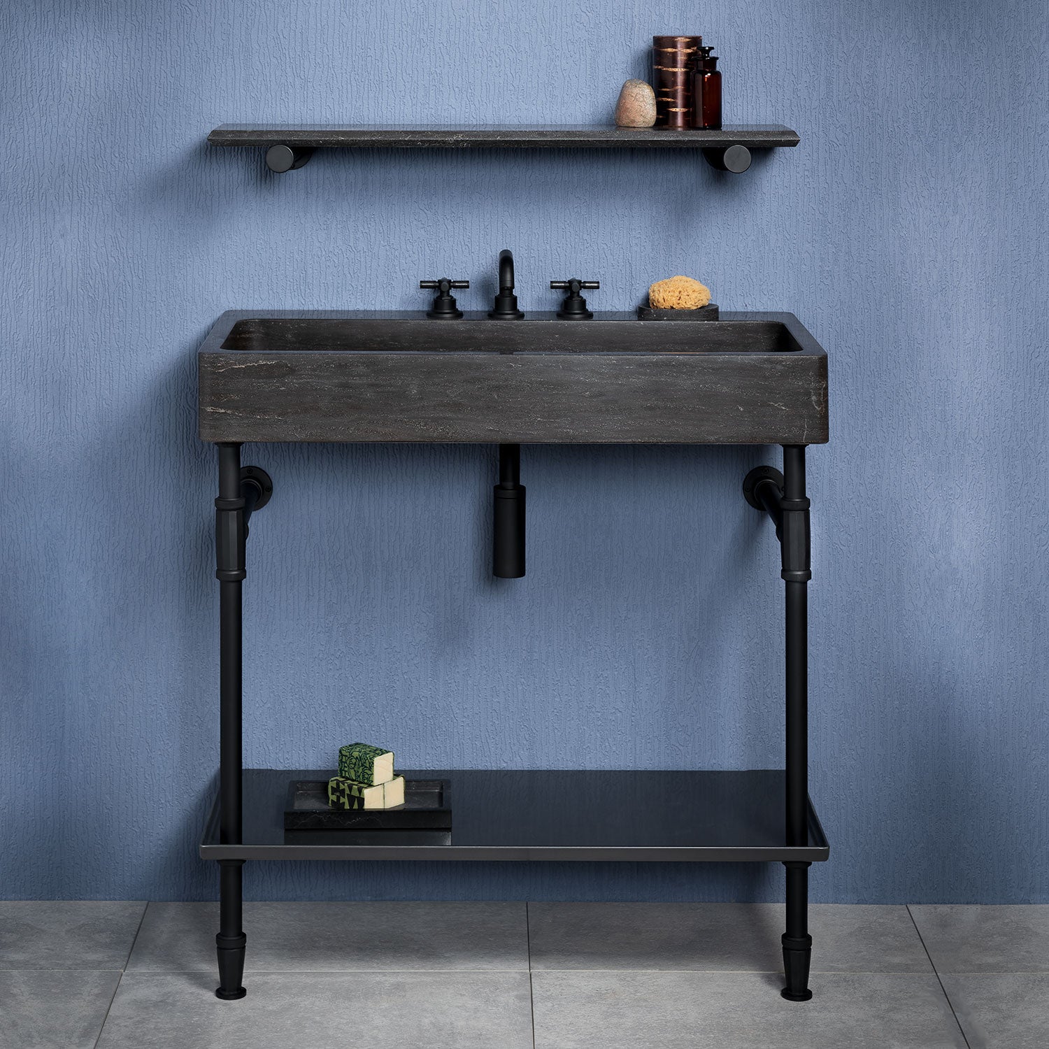 Antique gray limestone trough console with matte black elemental facet trough vanity legs and a metal tray.