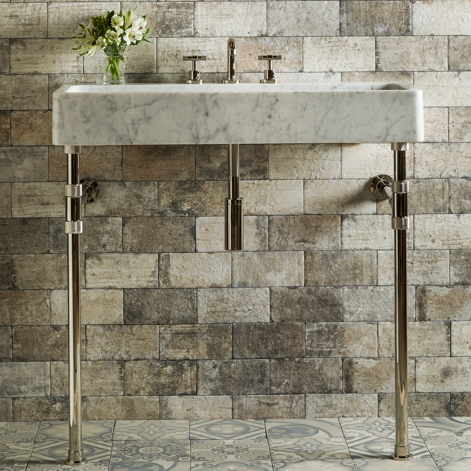A honed carrara marble trough sink paired with polished nickel elemental classic trough vanity legs