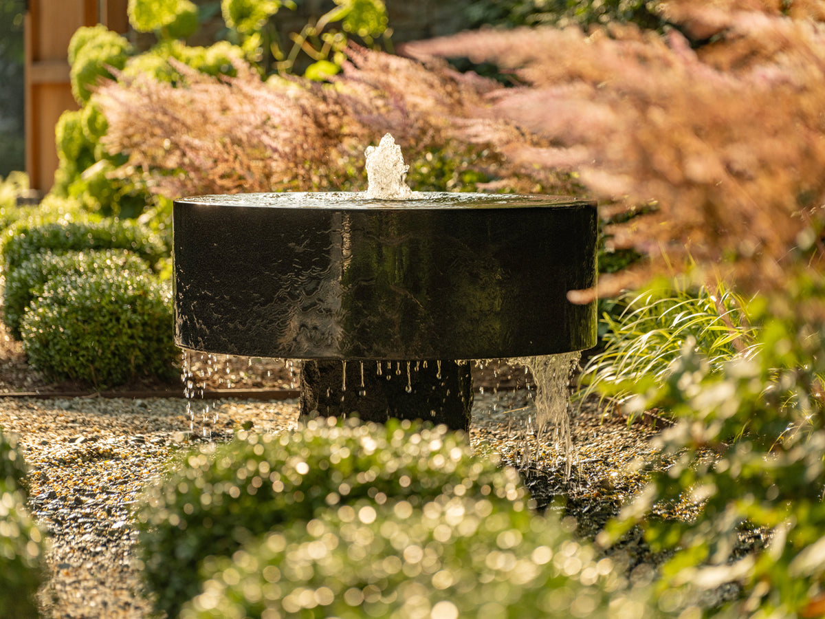 Polished black millstone installed in garden