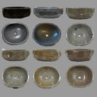 Collection of various stone vessel sinks on a gray background