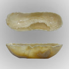A free-form onyx bowl with a smooth, curved shape, honey and beige coloring