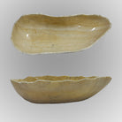 A free-form onyx bowl with a smooth, curved shape, beige