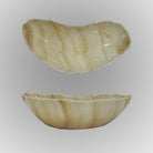 A free-form onyx bowl with a smooth, curved shape against a gray background.
