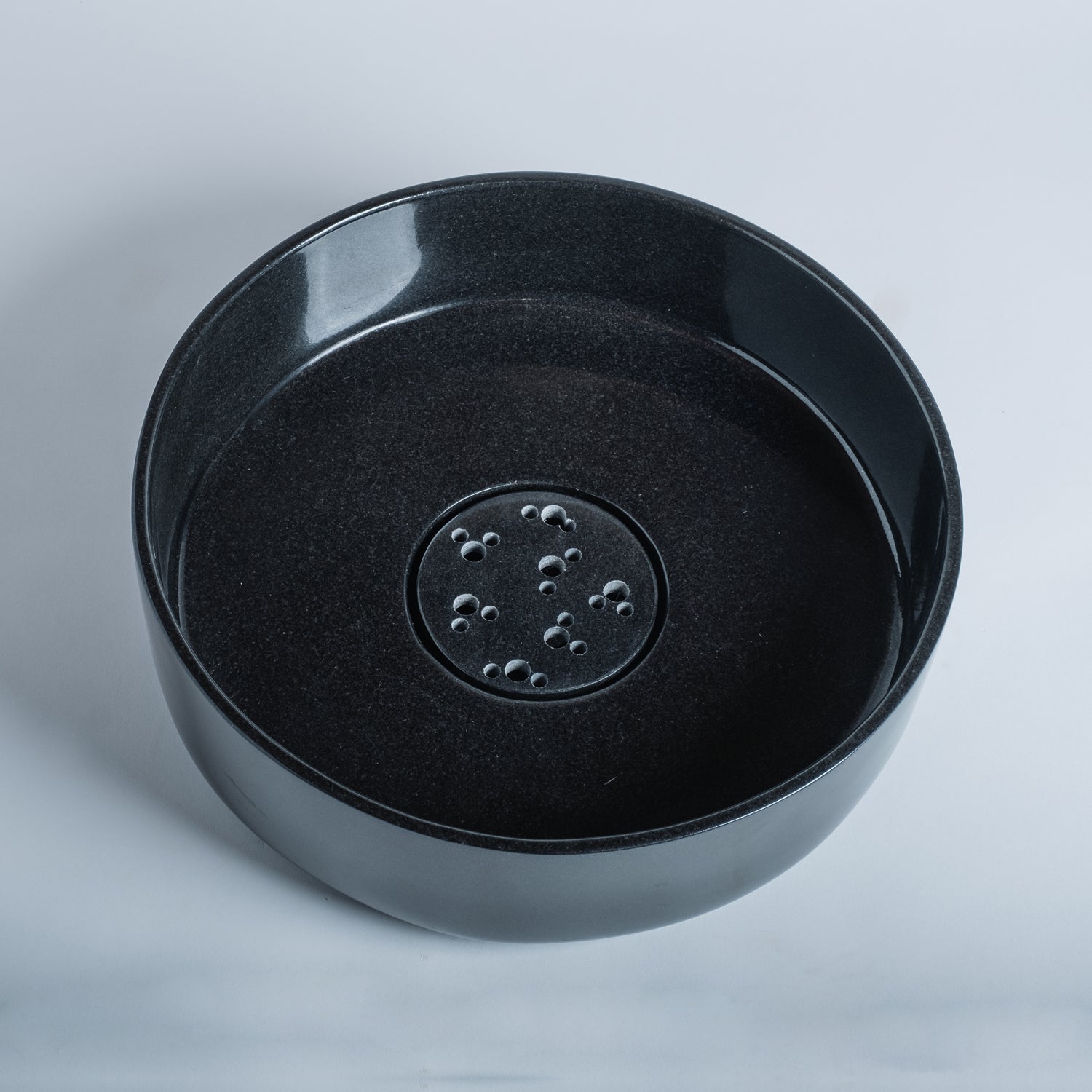 thin-walled vessel sink is carved from a solid block of black granite and finished to a high polish; Drain cover is included.