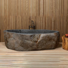 Natural boulder bathtub made of granite boulder. Natural exterior and polished rim and interior.