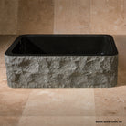 Black Granite farmhouse sink with polished interior and rim and rough chiseled apron.