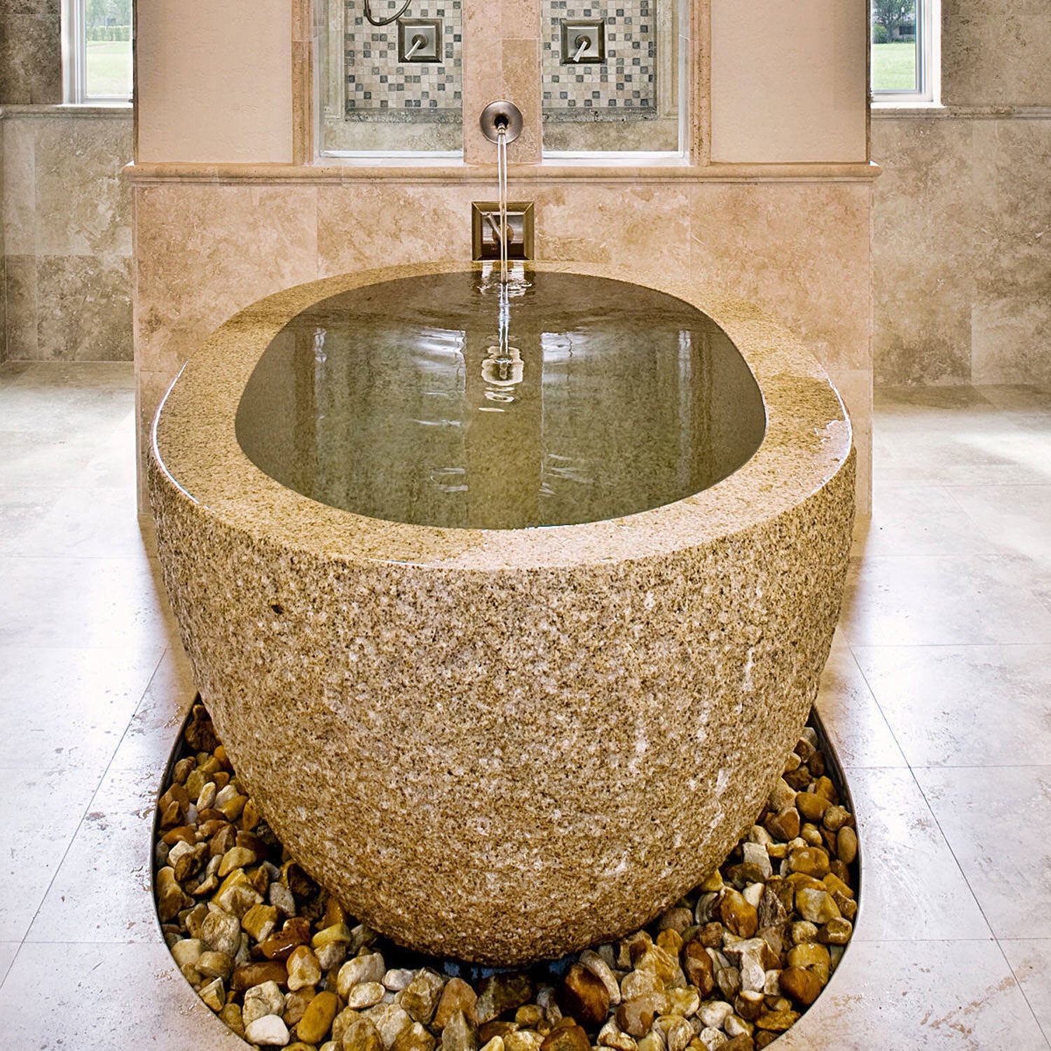 Oval bathtub with chiseled exterior in in beige granite