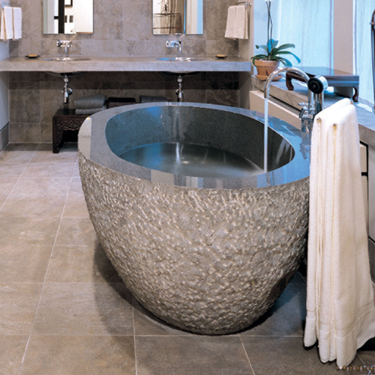 Oval bathtub in blue-gray granite with chiseled exterior and polished interior