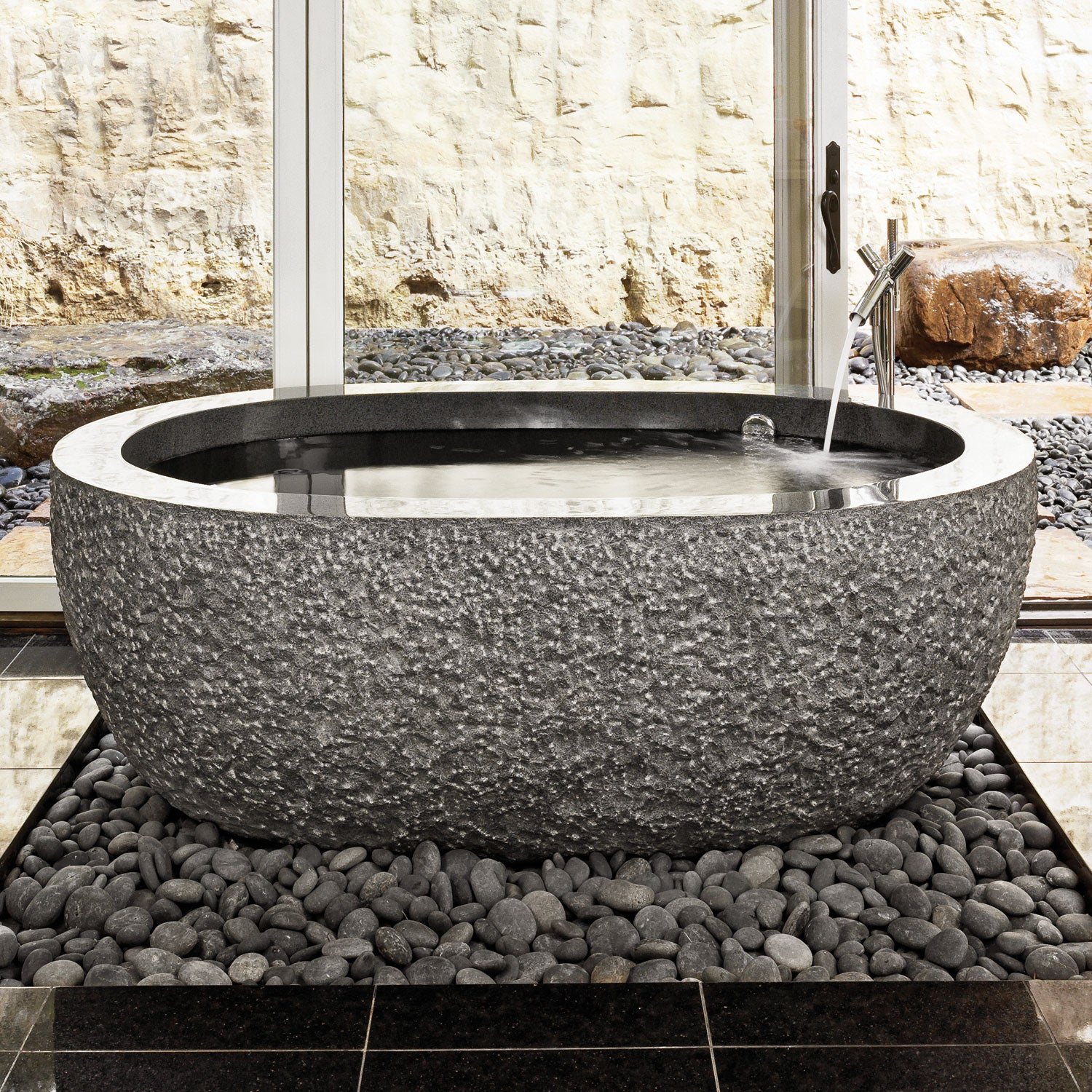 Oval bathtub in black granite polished interior with chiseled exterior