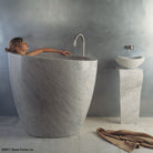 The free standing Stone Forest Eau Soaking Bathtub is hand-carved from a solid block of Carrara marble. Made on a custom basis.