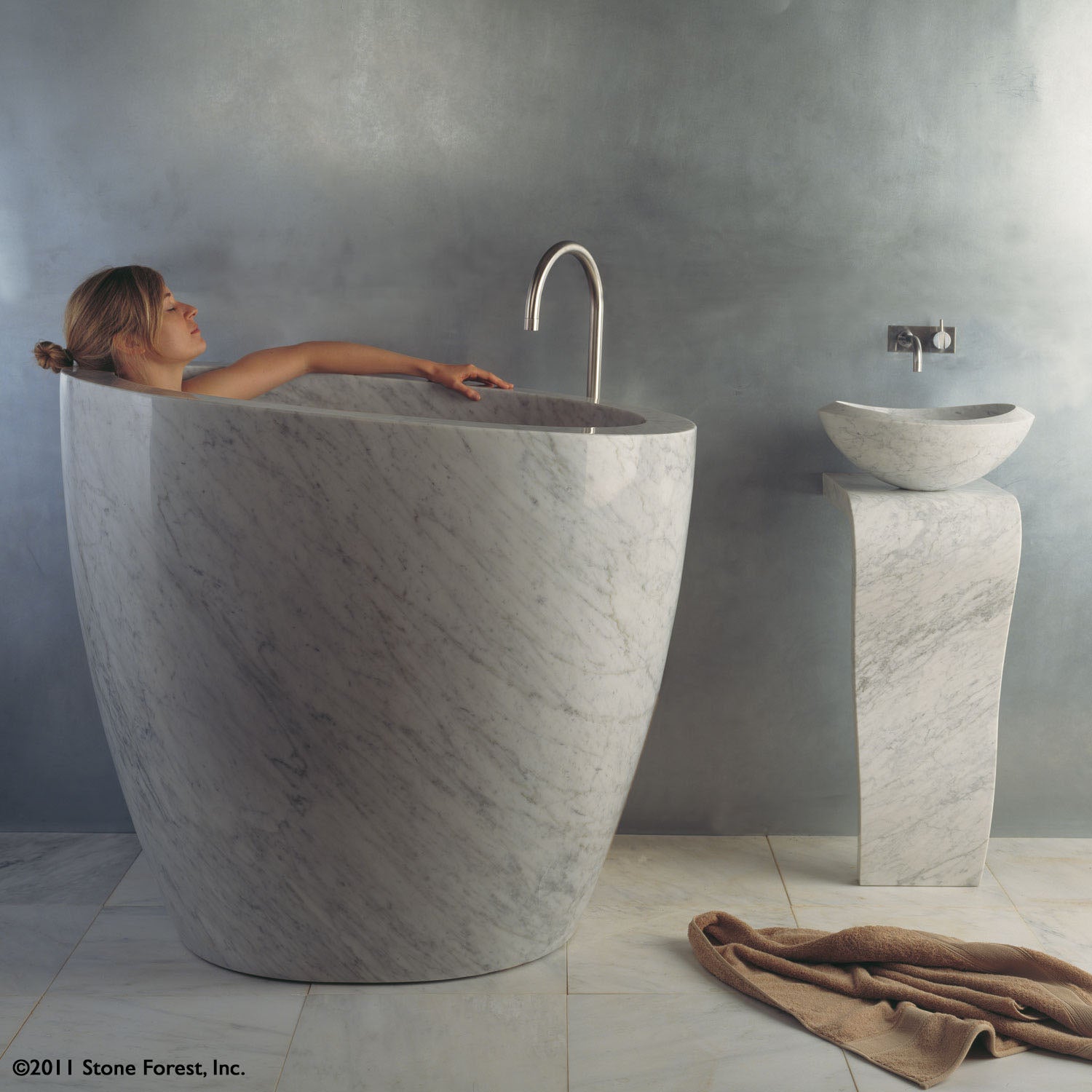 The free standing Stone Forest Eau Soaking Bathtub is hand-carved from a solid block of Carrara marble. Made on a custom basis.