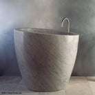 The free standing Stone Forest Eau Soaking Bathtub is hand-carved from a solid block of Carrara marble. Made on a custom basis.