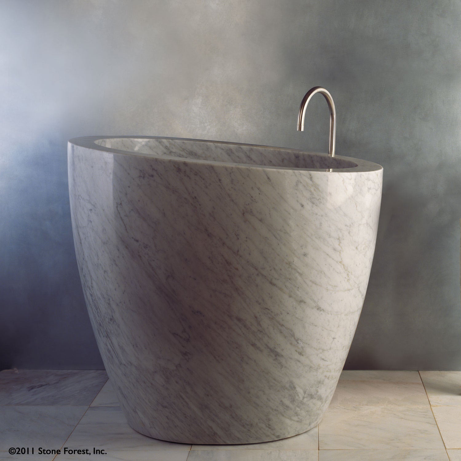 The free standing Stone Forest Eau Soaking Bathtub is hand-carved from a solid block of Carrara marble. Made on a custom basis.