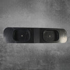Black stone sink with two basins on a gray concrete background