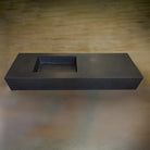 A black honed basalt vanity with a rectangular basin