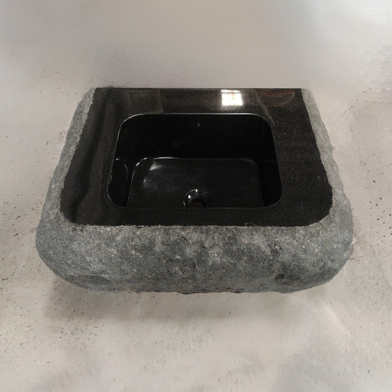 Custom Lavatory Vanity carved from black granite with rough chiseled exterior