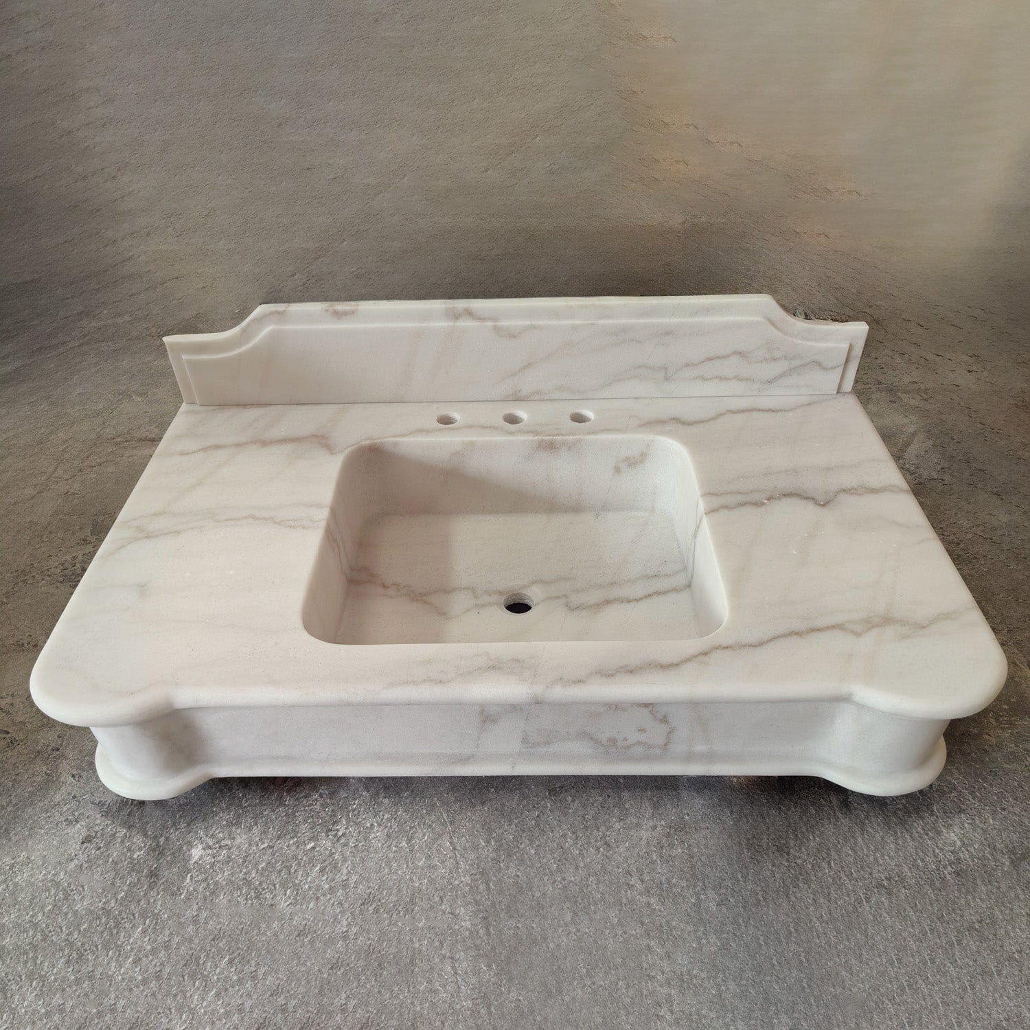 Luna Bianca Marble bathroom vanity with sink on a gray background
