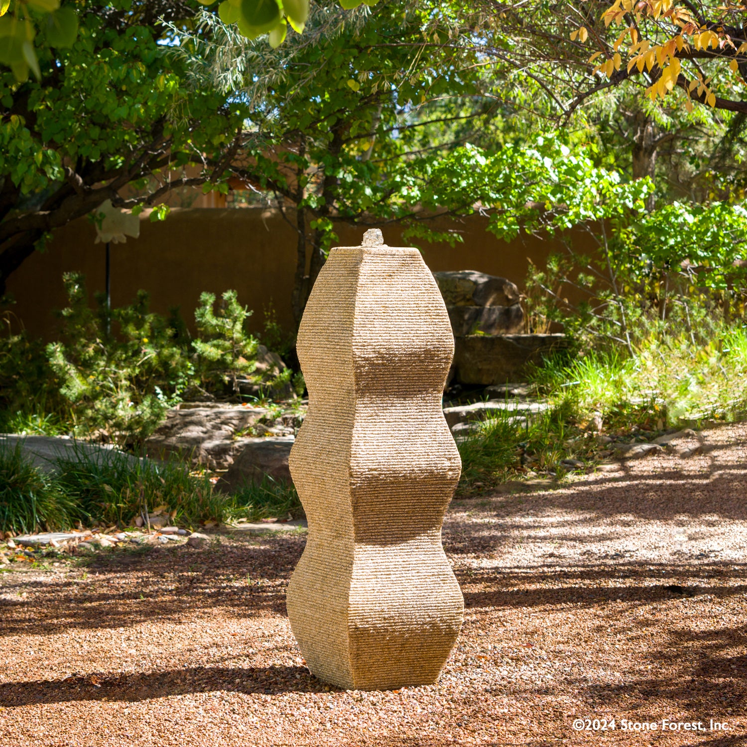 The Wave Fountain sculpted from a block of beige granite.