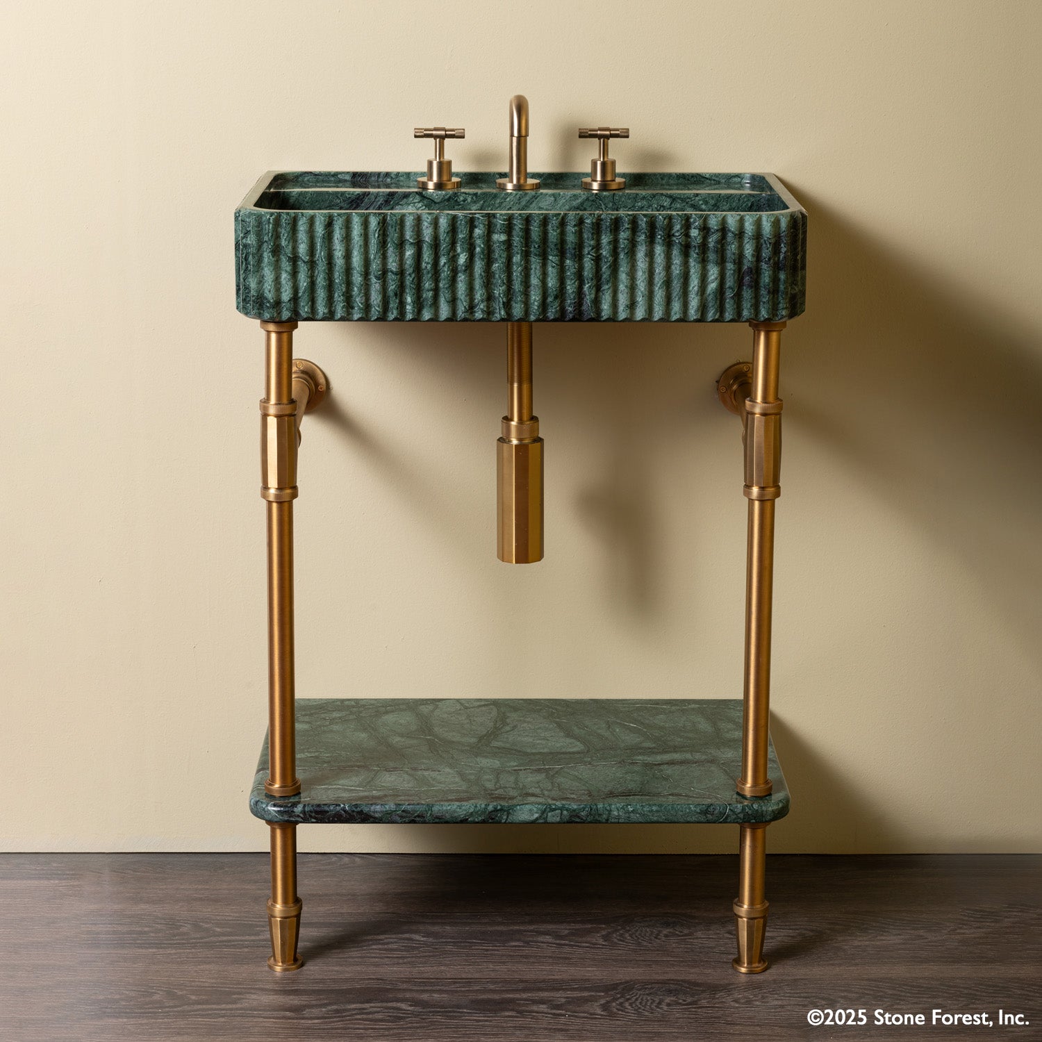 A green marble sink with Aged Brass brass fittings and legs, paired with a lower shelf that is also in green marble.