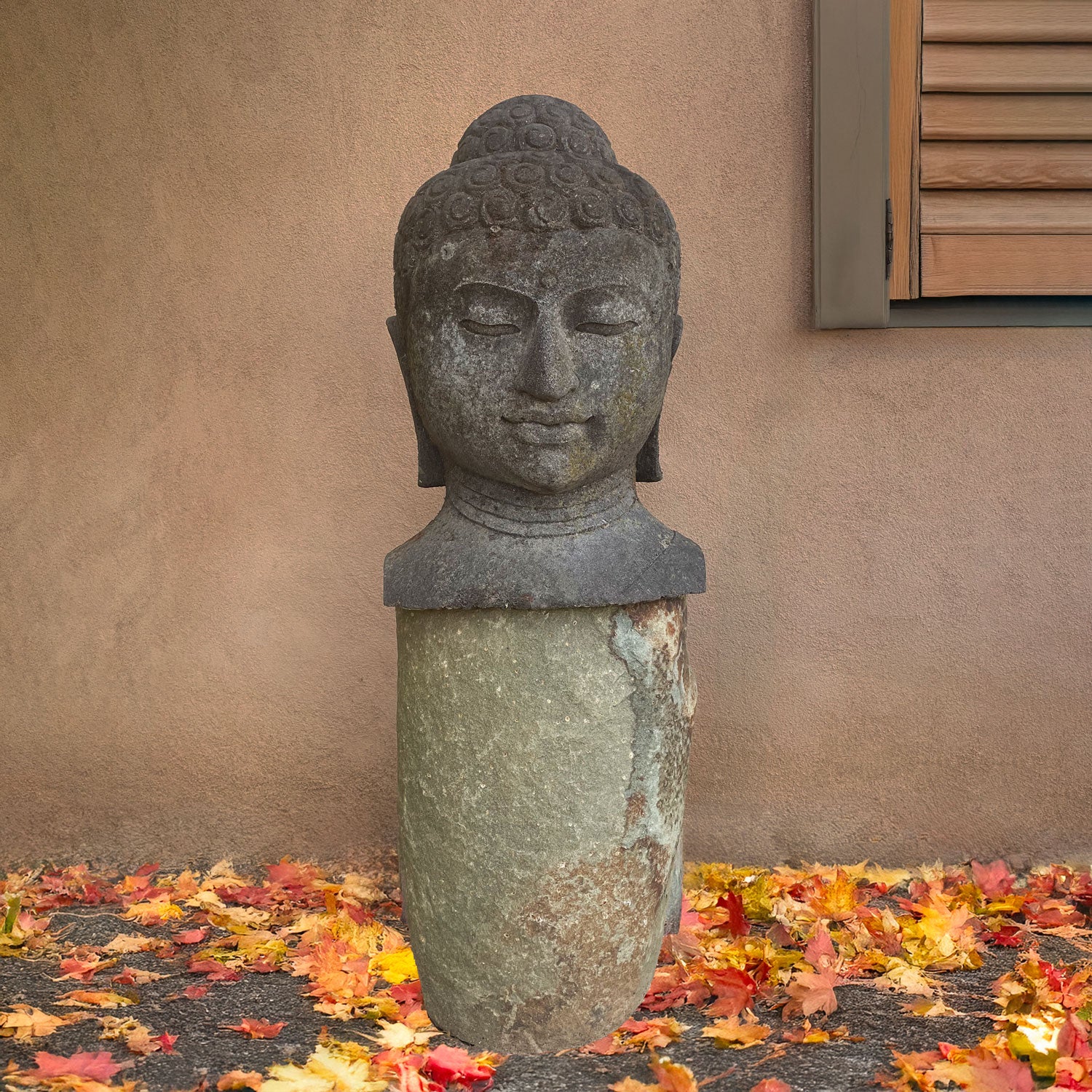 Large Buddha Head carved from stone on a granite pedestal