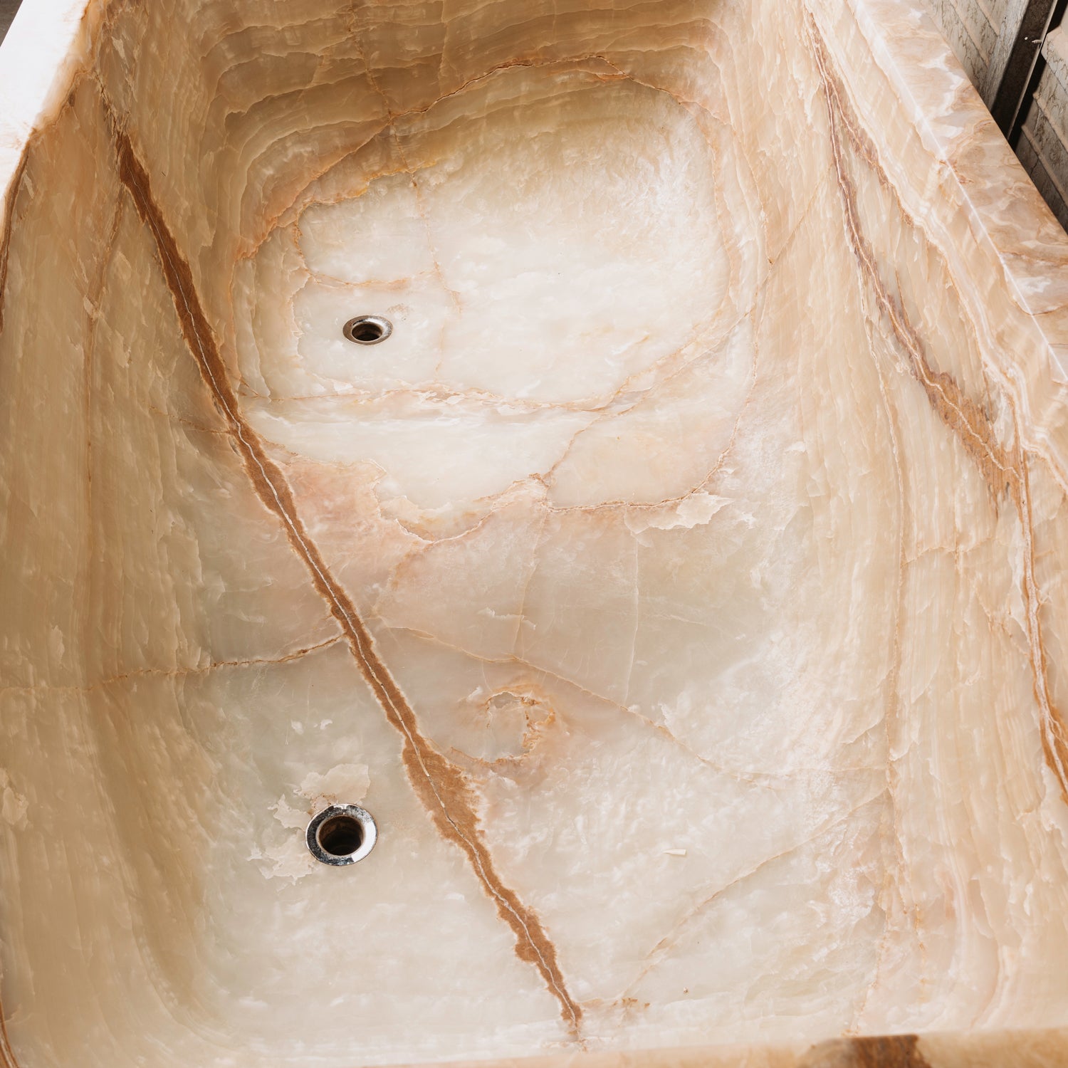 Detail of a large, rectangular onyx trough planter with multi-color patterns, 