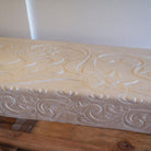 A beige marble vanity with carved details, close up of countertop and carving