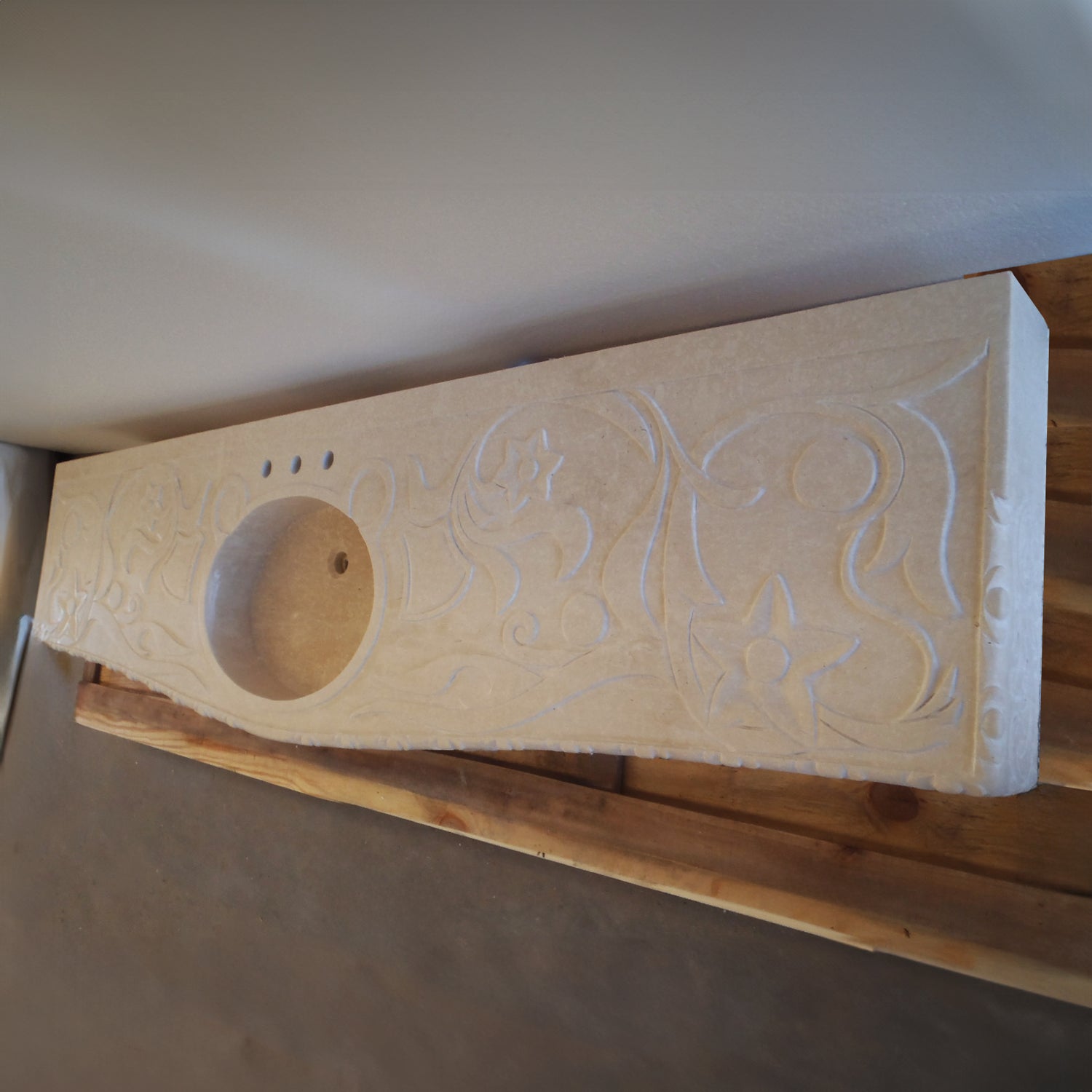 A beige marble vanity with carved details, angle shot