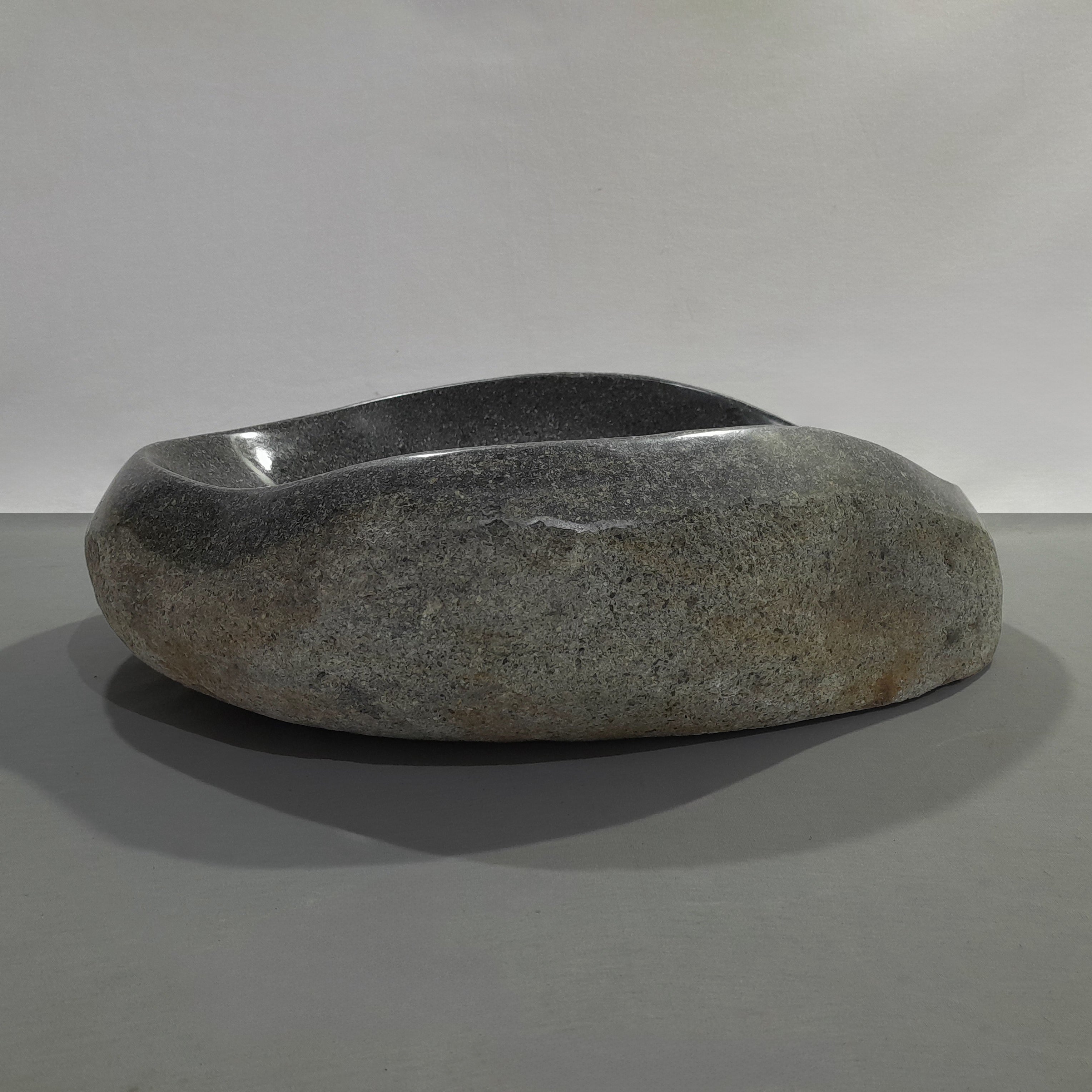 Natural stone sink on a gray background