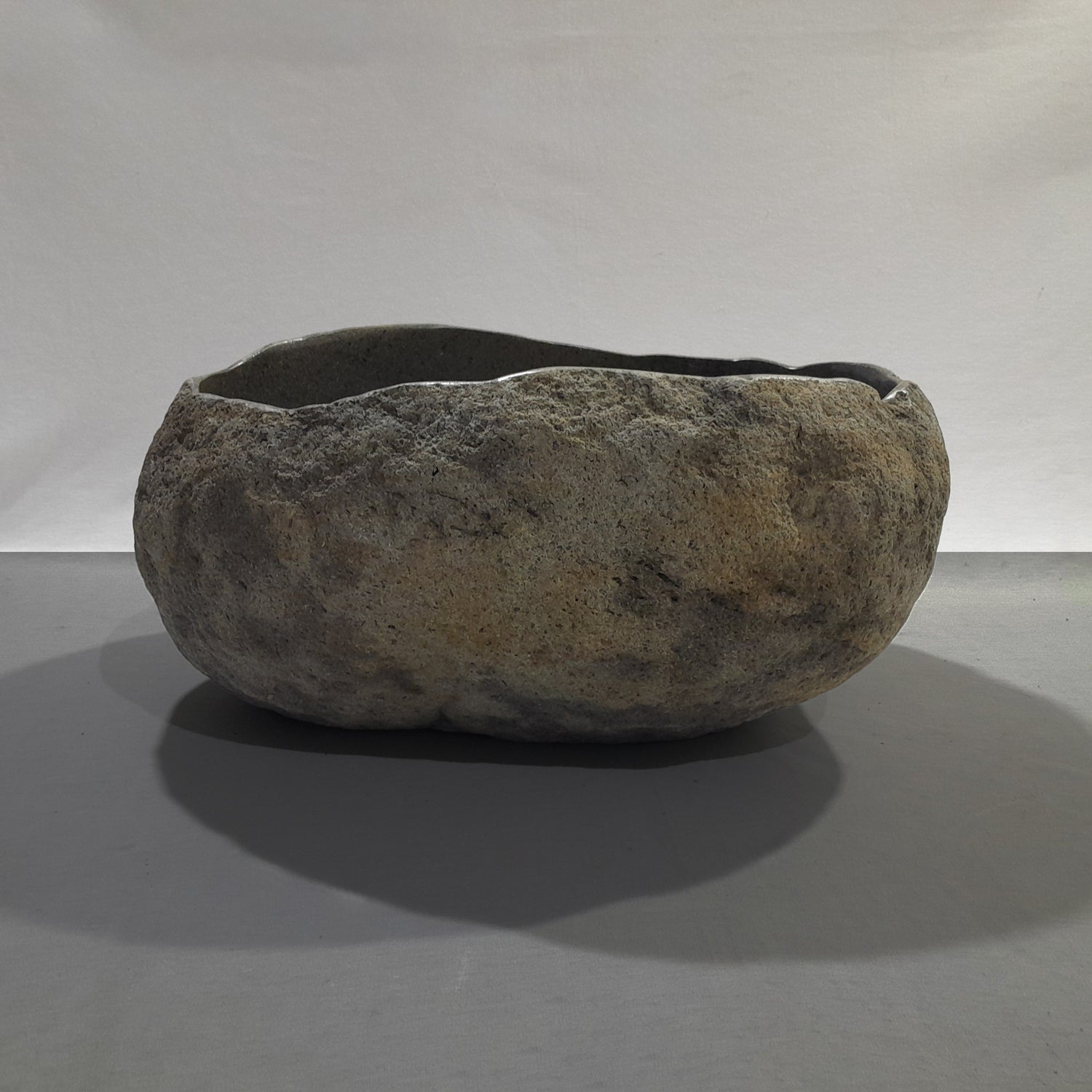 Natural stone sink on a gray background