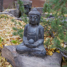A hand-carved dark limestone Buddha statue, seated 