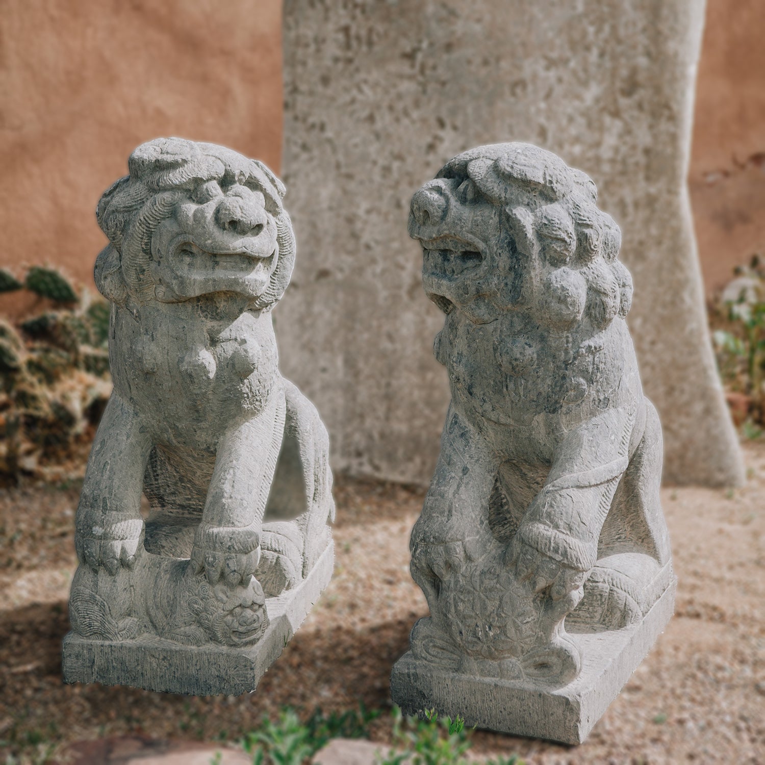 pair of antique stone lions were hand-sculpted from a block of dark limestone. They are also known as lion dogs or foo dogs/fu dogs.