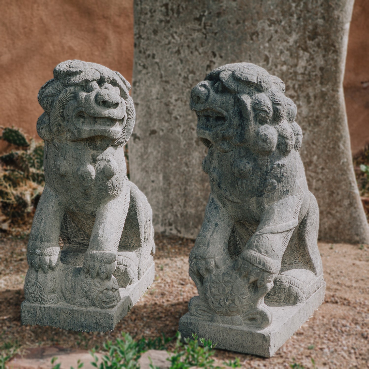 pair of antique stone lions were hand-sculpted from a block of dark limestone. They are also known as lion dogs or foo dogs/fu dogs.