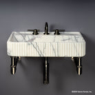 Fluted Lumbre Bath Sink carved from Viola Bianco Marble on an Elemental Facet Wall Unit in graphite
