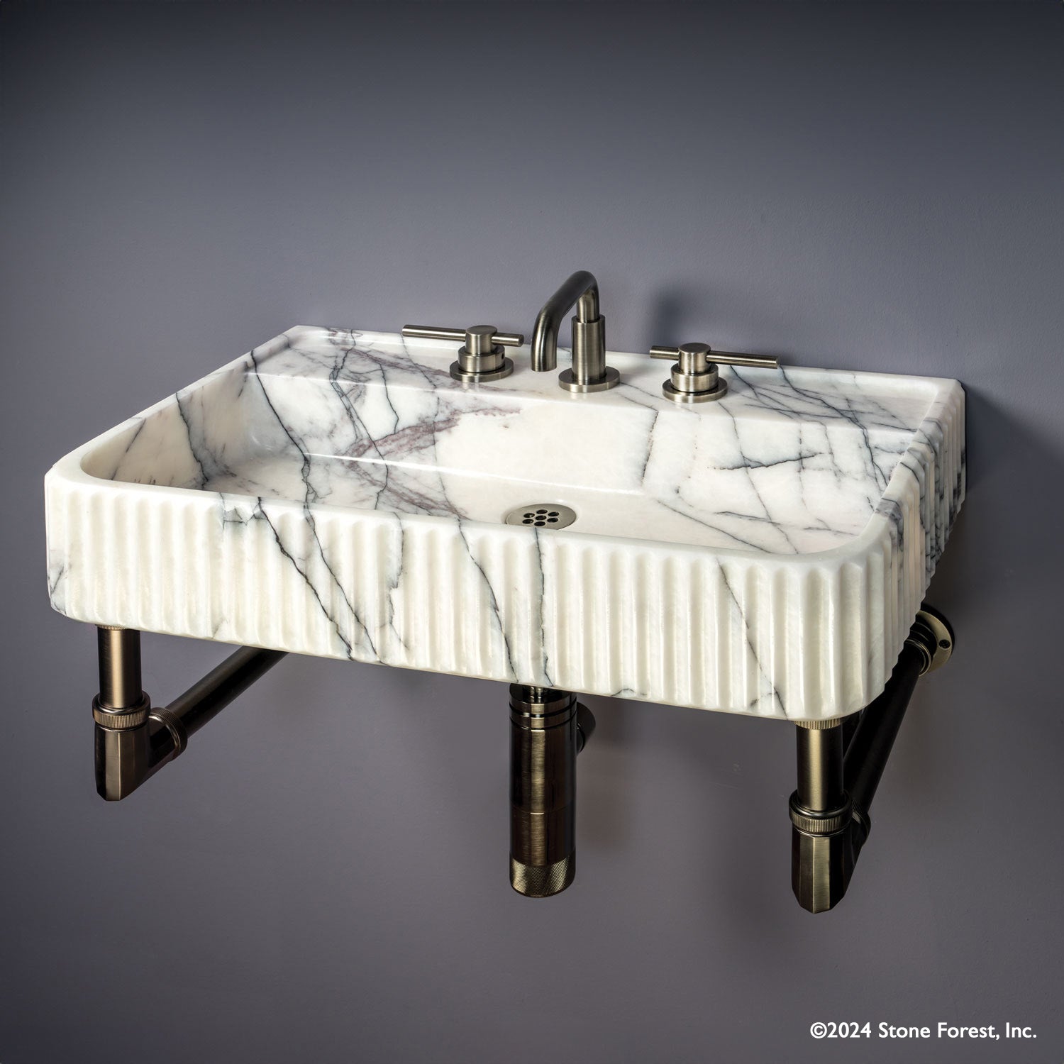 Fluted Lumbre Bath Sink carved from Viola Bianco Marble on an Elemental Facet Wall Unit in graphite