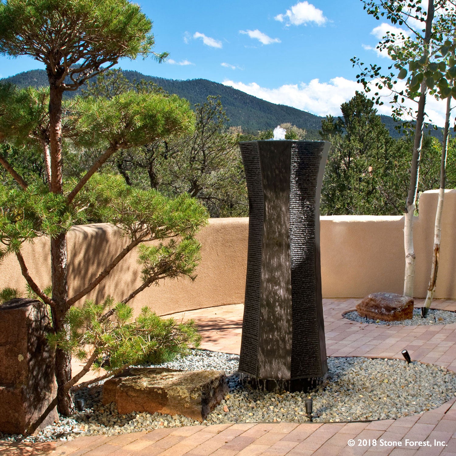 Stone Forest Stelae garden fountain carved from black granite.