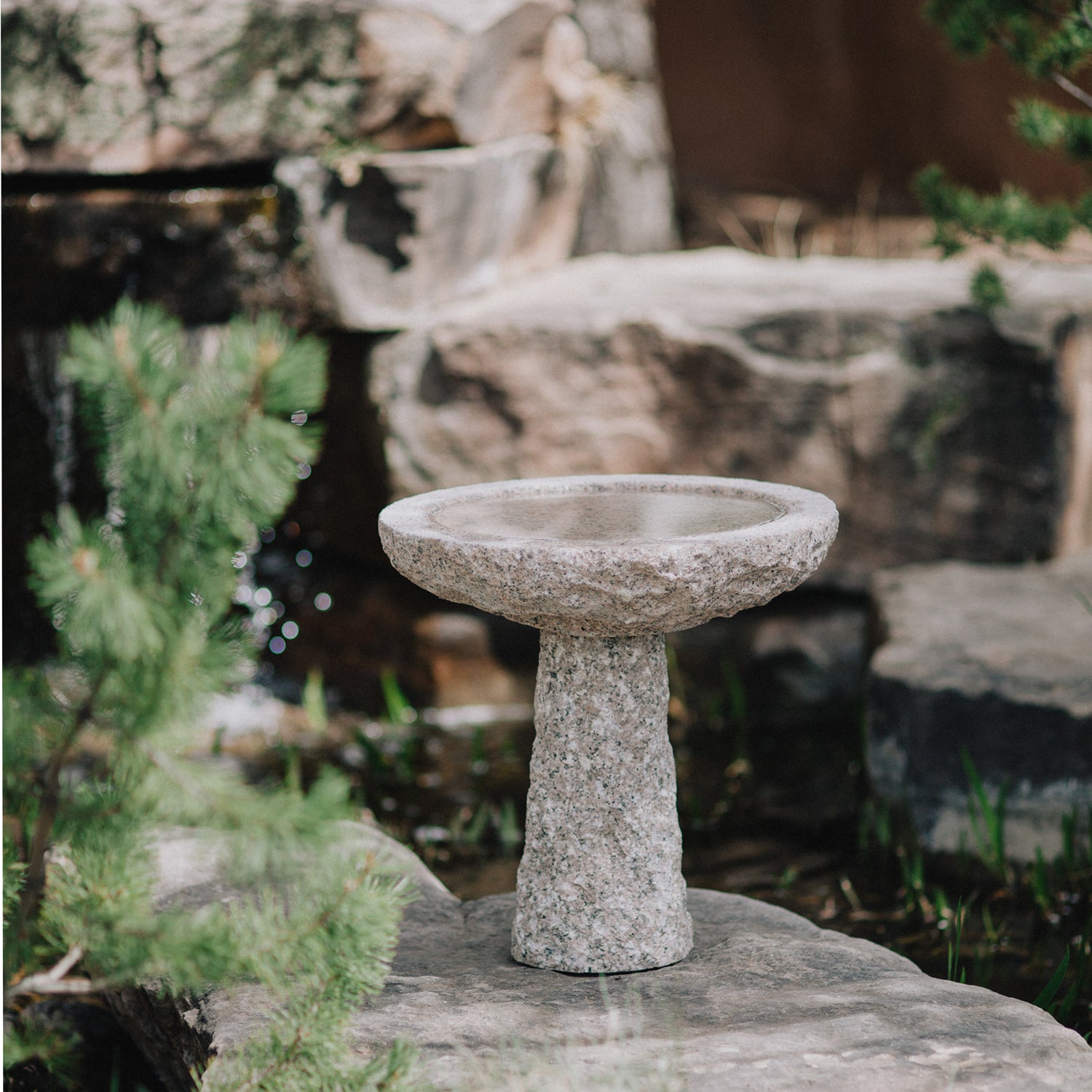 birdbath is hand-carved from Rose Granite with a rough chiseled finish