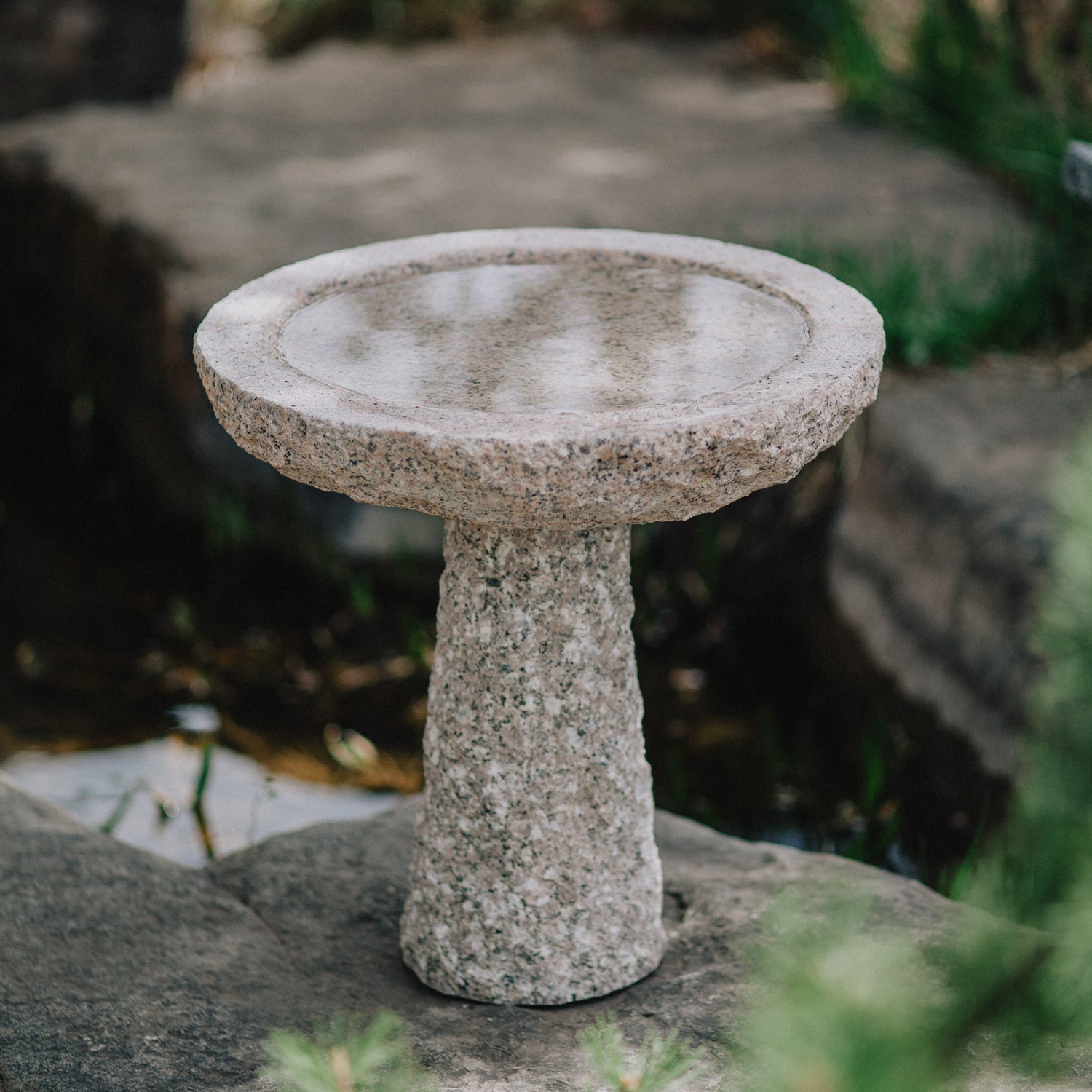 birdbath is hand-carved from Rose Granite with a rough chiseled finish