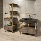 Antique gray limestone Terra bath sink supported by an Elemental Classic vanity with a wood drawer. With Storage Unit to the left.