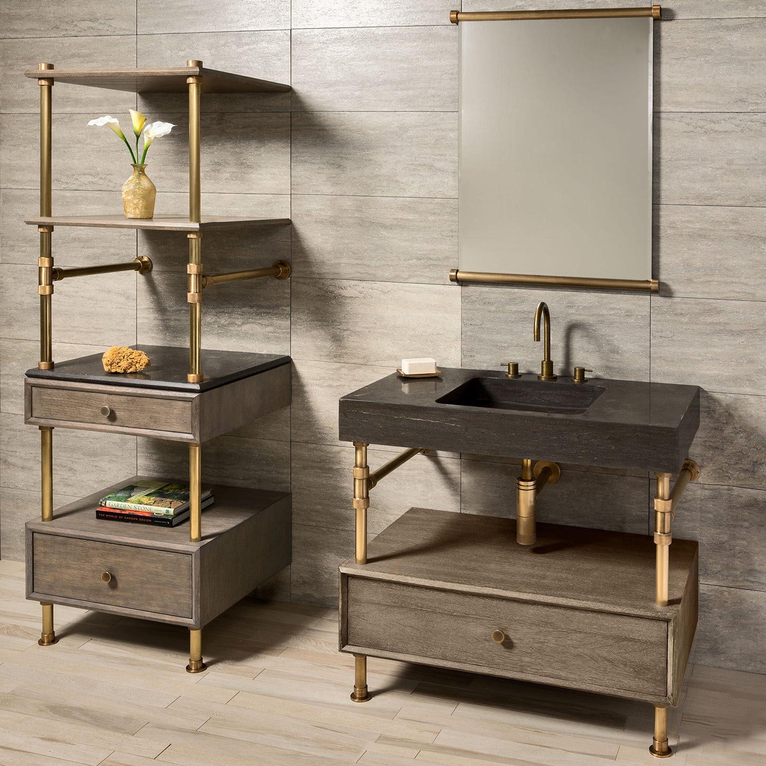 A Terra Bath Sink with aged brass legs, placed on a console stand, accompanied by a drawer vanity with a cement gray wood drawer. The backdrop features a tiled wall and a mirror.