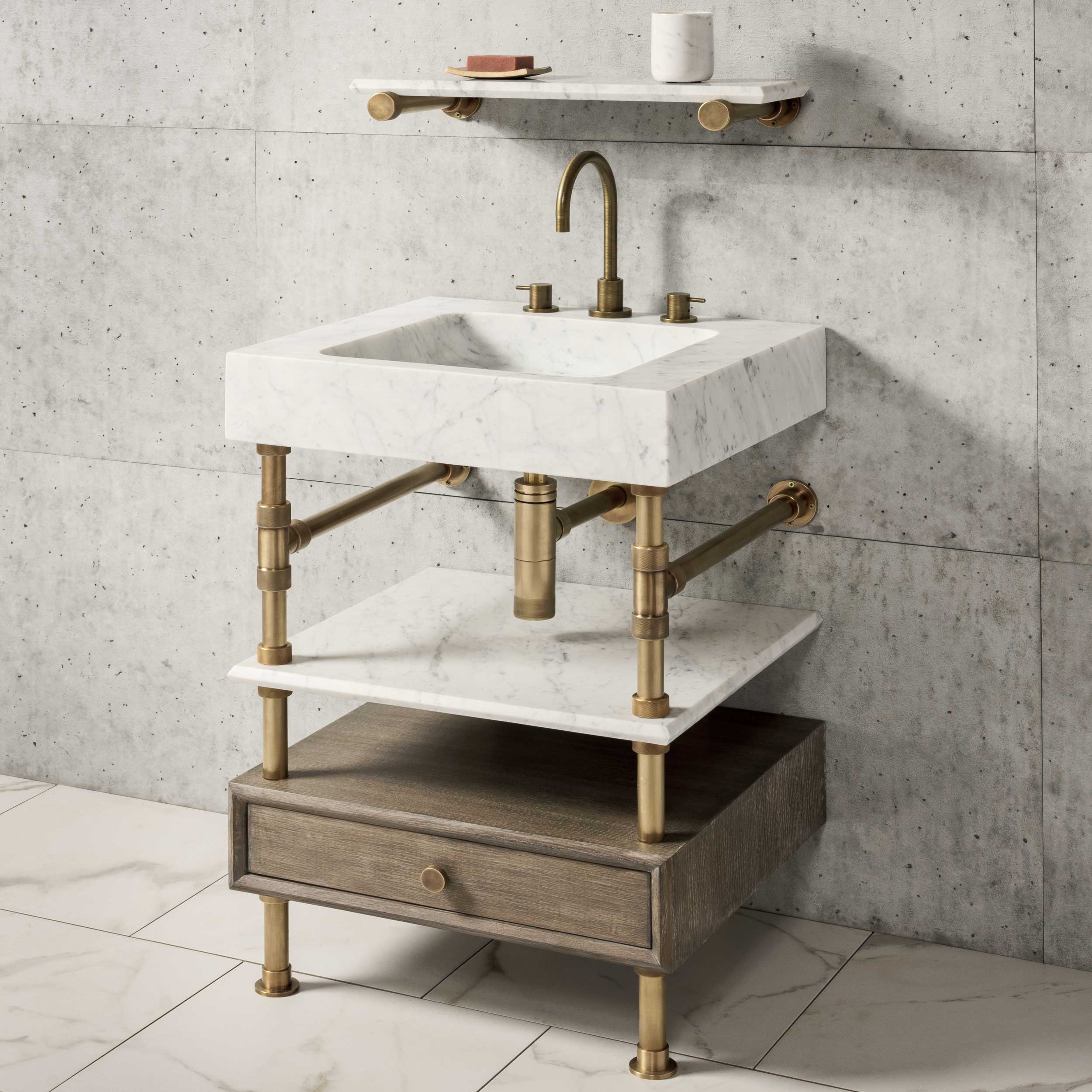 A carrara marble Terra bath sink with aged brass legs, with cement gray wooden shelf with a small drawer.
