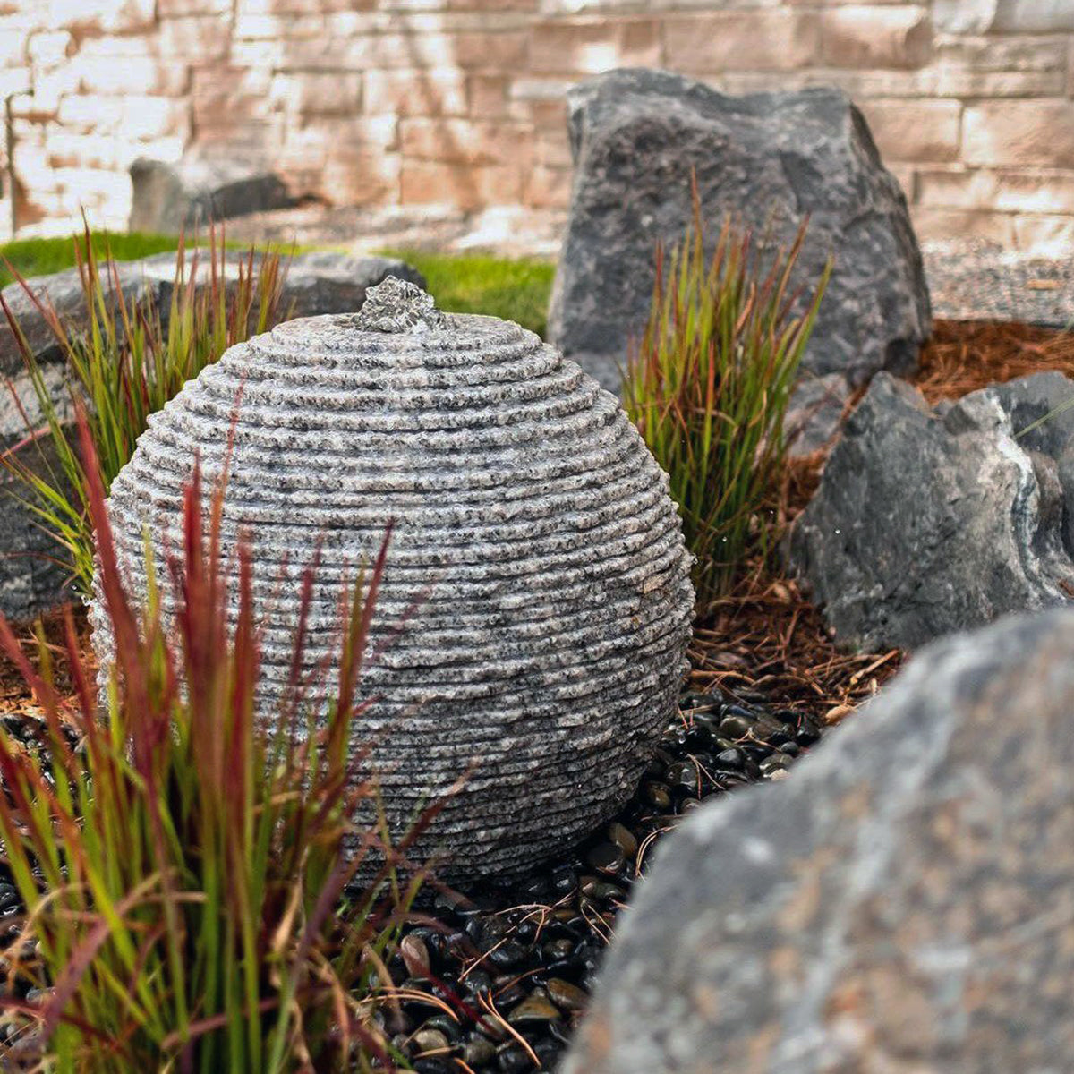 Stone Forest Ribbed Sphere garden fountain carved from black and white granite 20"h